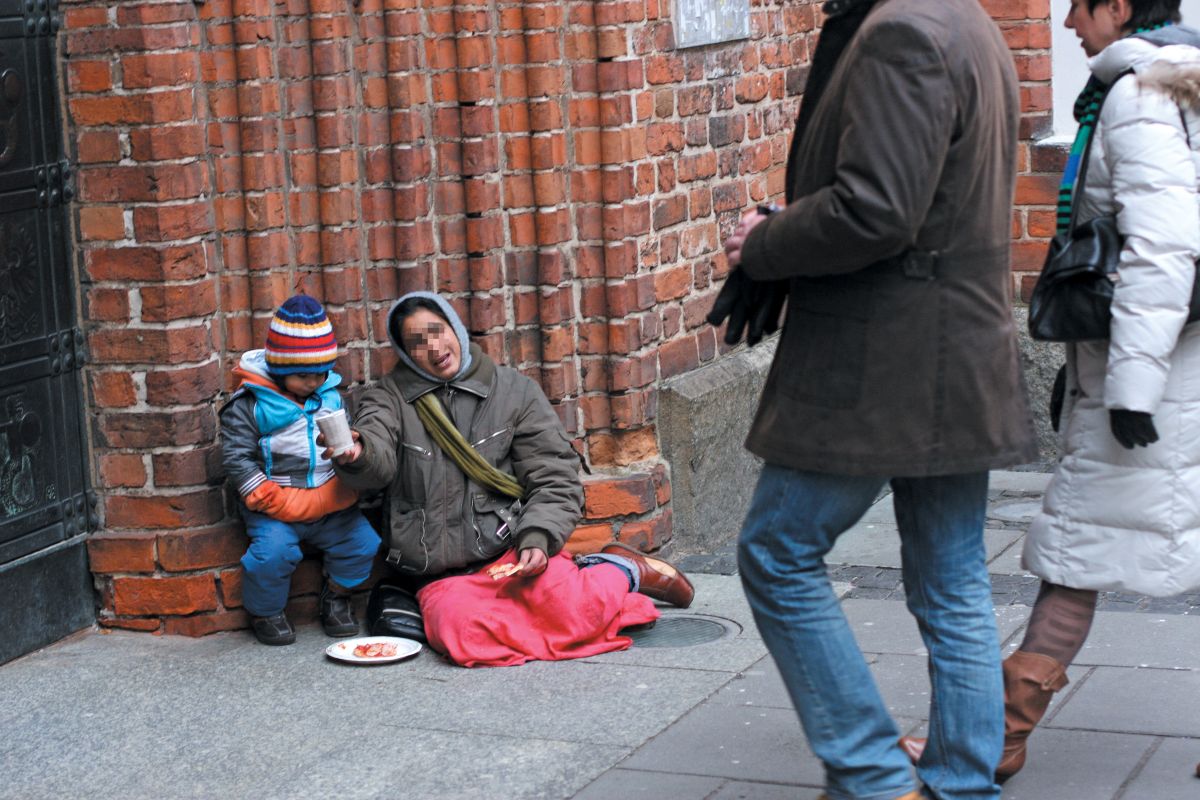 kobietę z dzieckiem żebrzącą pod wejściem do kościoła, dwie osoby idące obok