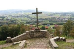 sprzątanie cmentarzy z I wojny światowej wielki krzyż na tle panoramy górskiej i miejscowości