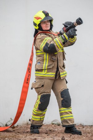 policjantka w stroju strażackim z wężem gaśniczym