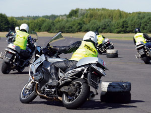 Policjanci ćwiczą manewry na motocyklach bmw na torze w zakrętach i przy hamowaniu i w slalomie. pochyły i zakręty