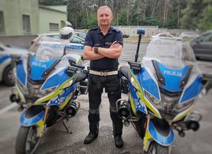 policjant stoi pomiędzy dwoma motocyklami policyjnymi