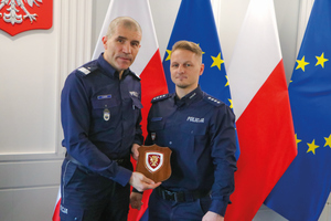 policjanci stoją przy flgach polski i unii