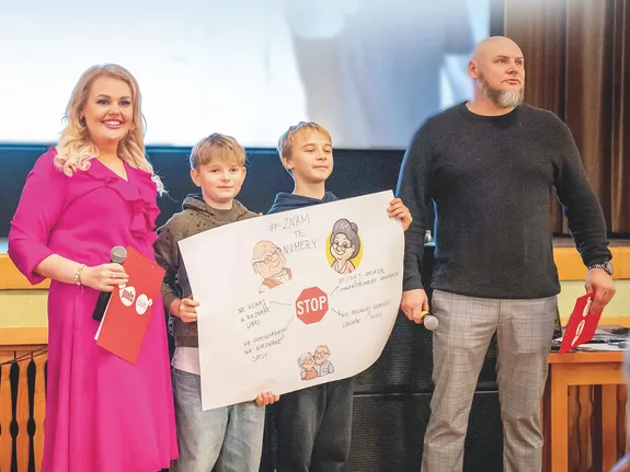 osoby stoją na scenie dwoje dzieci, dwoje dorosłych i policjant. Dzieci trzymają zwycięski plakat