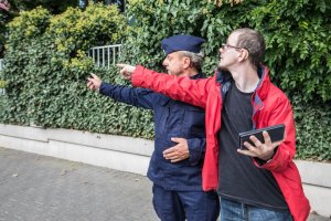 Osoba głuchoniema pokazuje policjantowi miejsce zdarzenia trzymając telefon z uruchomioną aplikacją
