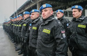 polscy policjanci stoją w rzędzie na odprawie w mundurach ONZ