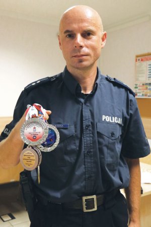 asp. Piotr Ścigała. trzyma zdobyty w kolarstwie medal