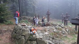 sprzątanie cmentarzy z I wojny światowej uczestnicy pracują wśród krzyży