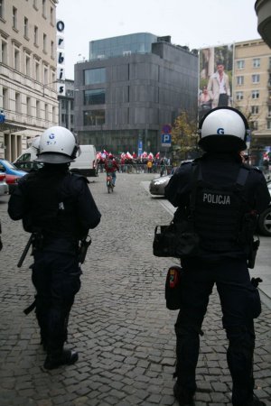 dwóch policjantów stoi tyłem na ulicy