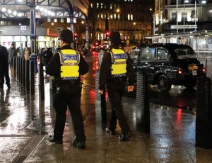 dwóch brytyjskich policjantów idzie chodnikiem przez miasto