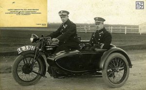 Przygoda to postać autentyczna, komisarz śledczy przedwojennej Policji Państwowej, w tym i warszawskiej. siedzi w wózku motocykla który prowadzi jego podwładny. obaj policjanci są w mundurach jest to skan starej fotografii