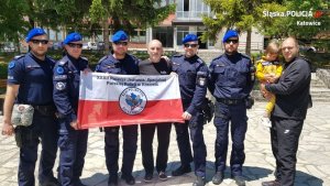 policjantami z XXXII. zmiany Jednostki Specjalnej polskiej Policji trzymają flagę polski podczas spotkania z uratowanym