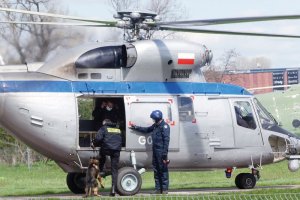 Ćwiczenia z przewodnikami psów służbowych w Krakowie helikopter, obok pilot trzyma drzwi a przewodnik z psem wskakują do środka