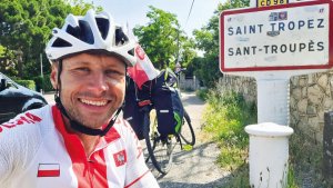 rowerzysta przed tablicą saint tropes we francji w tle rower