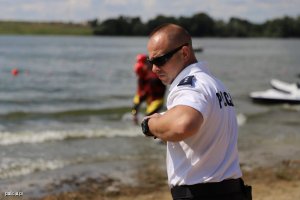 Komisarz Maciej Kujawiński stoi bokiem nad jeziorem