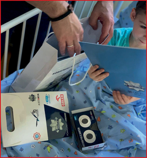 dziecko na łóżku szpitalnym przegląda folder policyjny