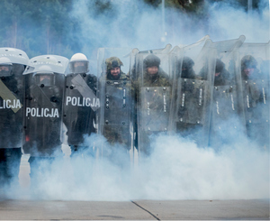 kordom policjantów i żołnierzy w kłębach gazu łzawiącego prze do przodu