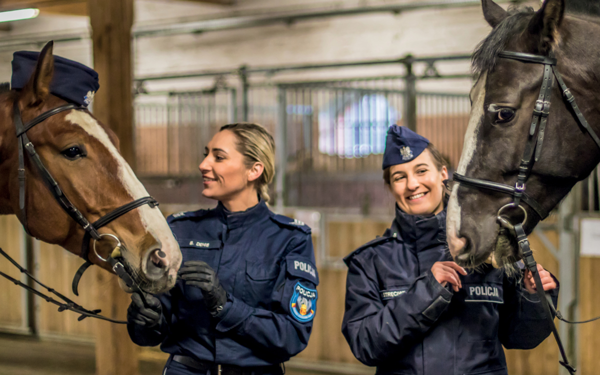zdjęcie okładkowe z końmi stoją policjantki i patrzą na swoje konie