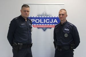 asp. Remigiusz Sobecki i mł. asp. Marcin Kasiorek na tle ściany z gwiazdą policyjną