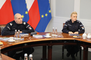 grupa policjantów i policjantek z komendantem i dyrektor biura na konferencji z materiału