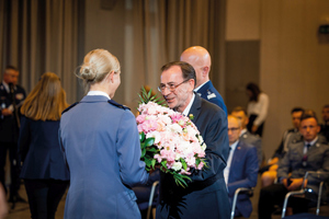 minister Kamiński wręcza medal i kwiaty policjantce