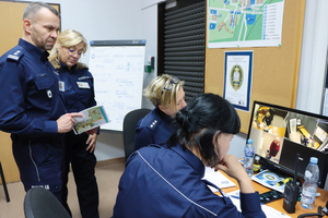 zawody dyżurnych grupa policjantów stoi przed komputerem