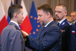 minister kierwiński przypina medal policjantowi