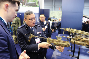 zdjęcia z targów polsecure 2024 mundurowy obcokrajowiec ogląda broń automatyczną