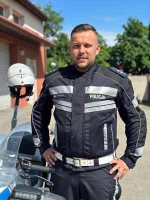 asp. Przemysław  Patelczyk w stroju motocyklowym stoi przy motocyklu