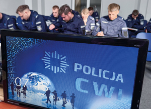 policjanci piszą testy siedzą na krzesełkach i używają programu multimedialnego na komputerze