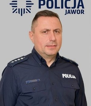 policjanci stoją przy radiowozach i przy budynkach pozując do zdjęcia do materiału