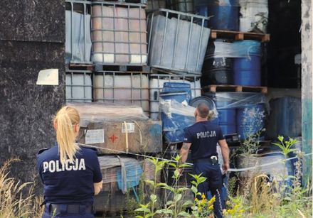 policjanci chodzą po placu pełnym odpoadów chemicznych i niezidentyfikowanych