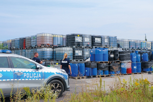 policjanci chodzą po placu pełnym odpoadów chemicznych i niezidentyfikowanych