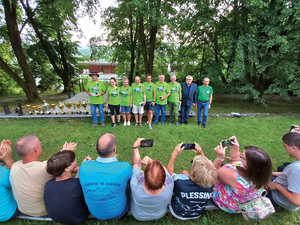 wygrani w rajdzie beskid szereg ludzi odzianych w zieleń stoi w pobliżu pucharów być może to zwycięzcy rajdu beskid