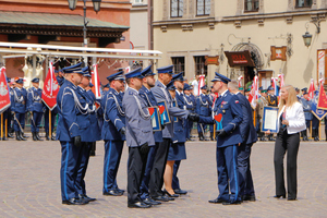 policjanci w szyku na placu przyjmują nagrody od policjanta naprzeciwko