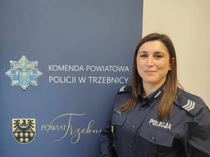 policjanci przy ściance komendy pozują do zdjęcia