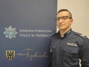 policjanci przy ściance komendy pozują do zdjęcia