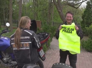 Krzysztof Chrzanowski trzyma kamizelkę z napisem Policja Prasa podczas materiału z użyciem motocykle. Obok Katarzyna Chrzanowska