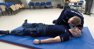 policjant demonstruje pierwszą pomoc na pozorancie i manekinie