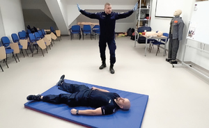 policjant demonstruje pierwszą pomoc na pozorancie i manekinie