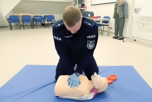 policjant demonstruje pierwszą pomoc na pozorancie i manekinie