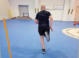 zawodnik ćwiczy na hali sportowej rzuty piłką, brzuszki, bieg