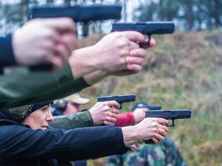 Policjanci na strzelnicy strzelający z broni krótkiej.