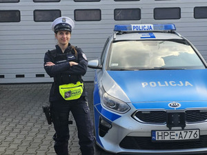 Policjantka ruchu drogowego przy radiowozie.