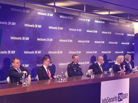 Komendant Główy Policji za stołem z innymi prowadzącymi konferencję.