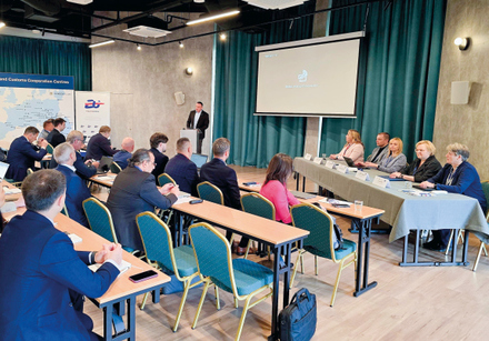 uczestnicy siedzą w ławkach przed prezydium pięcioosobowym i słuchają wykładowcy