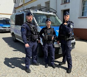 policjanci stoją przy radiowozach, komendach. na zewnątrz i wewnątrz. pozują do fotografii