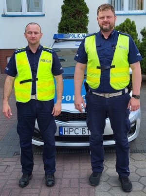 policjanci stoją przy radiowozach, komendach. na zewnątrz i wewnątrz. pozują do fotografii