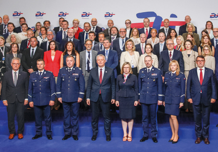 grupa uczestników stoi na podium i pozuje do zdjęcia grupowego