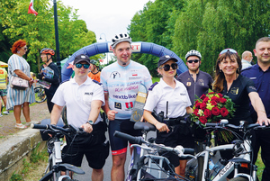 osoby z rowerami obok pozują do zdjęcia w tym dwoje policjantów