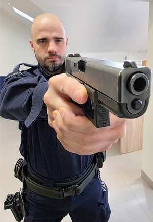 policjant ćwiczy z bronią służbową